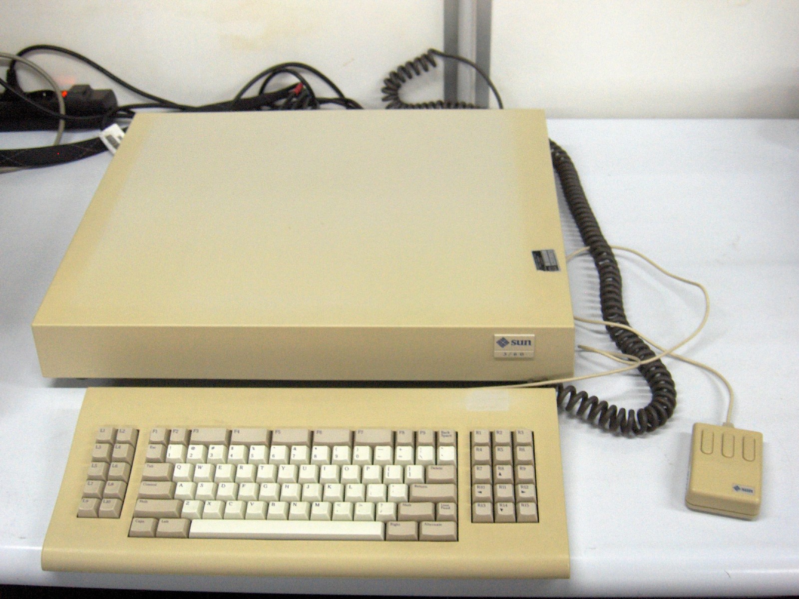 Photo: a beige Sun 3/60 workstation with a keyboard and a three-button mouse on a white table.