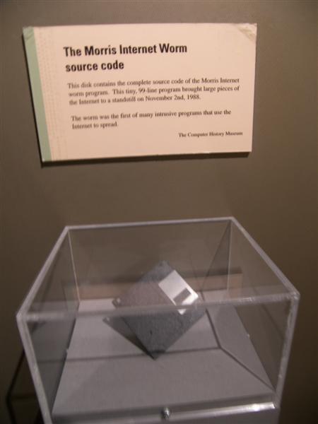 Photo: a floppy disk in a clear display case below a museum label reading The Morris Internet Worm source code.