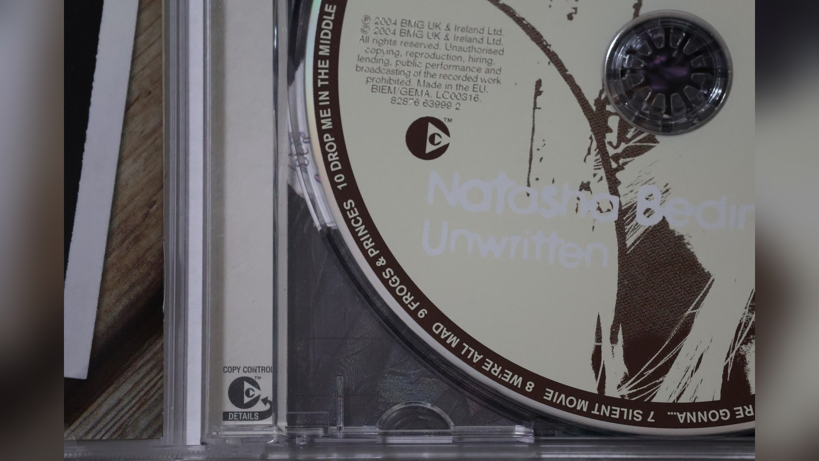 Photo: close-up of an open CD case with a disc inside and a small round Copy Control logo printed on the case.
