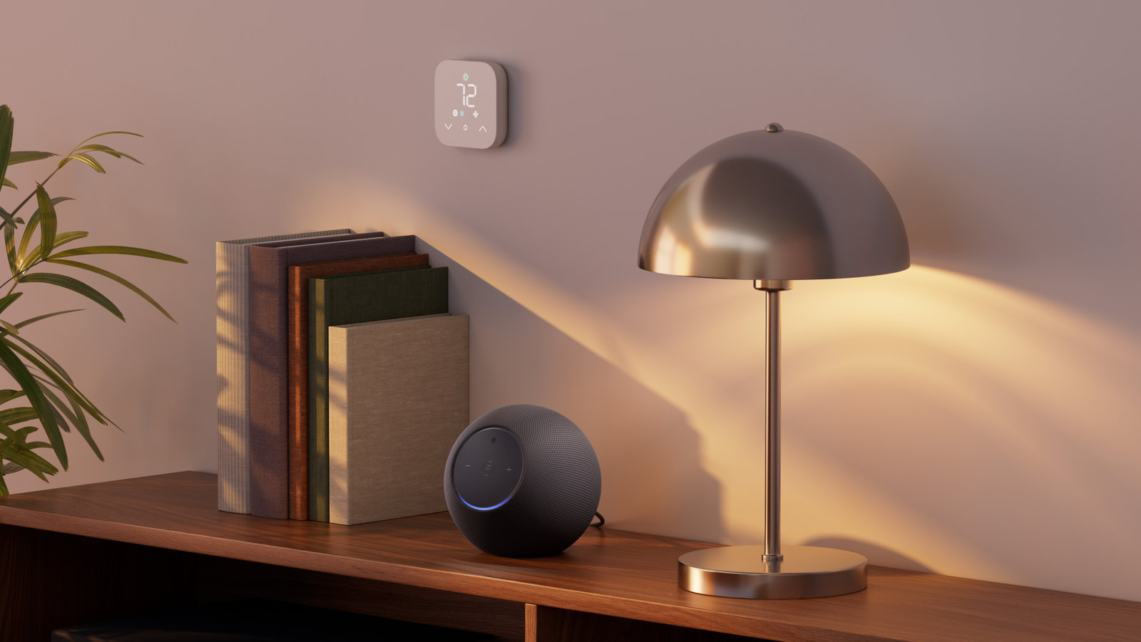 Photo: A dark gray Echo Studio speaker sits on a wooden shelf beside books and a table lamp.