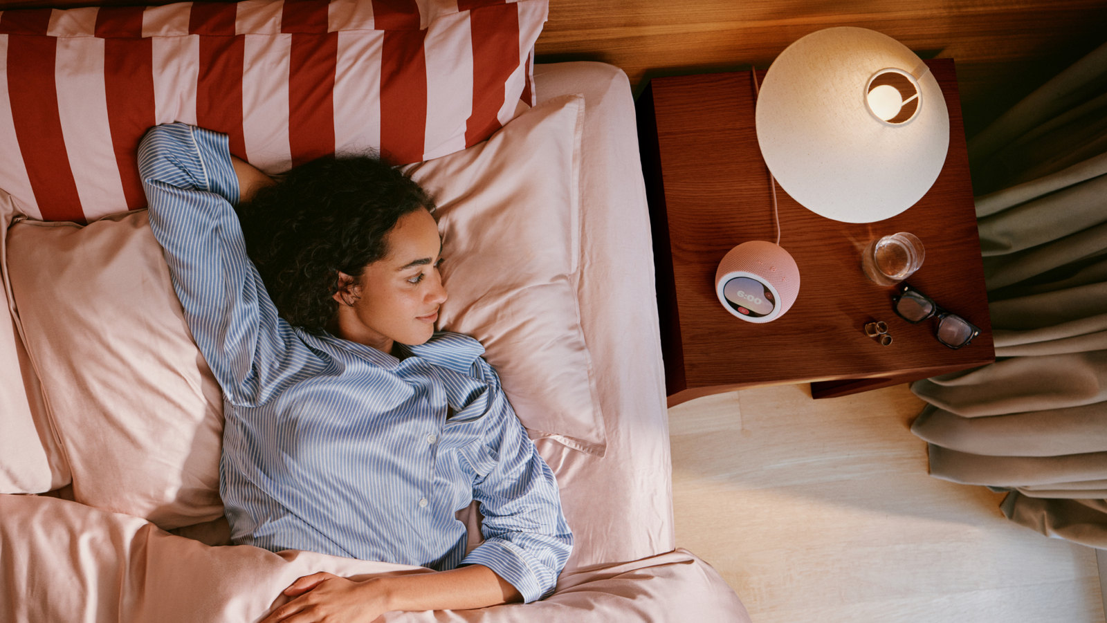 Photo: A woman wakes up in bed next to a pink Echo Time clock on her nightstand.
