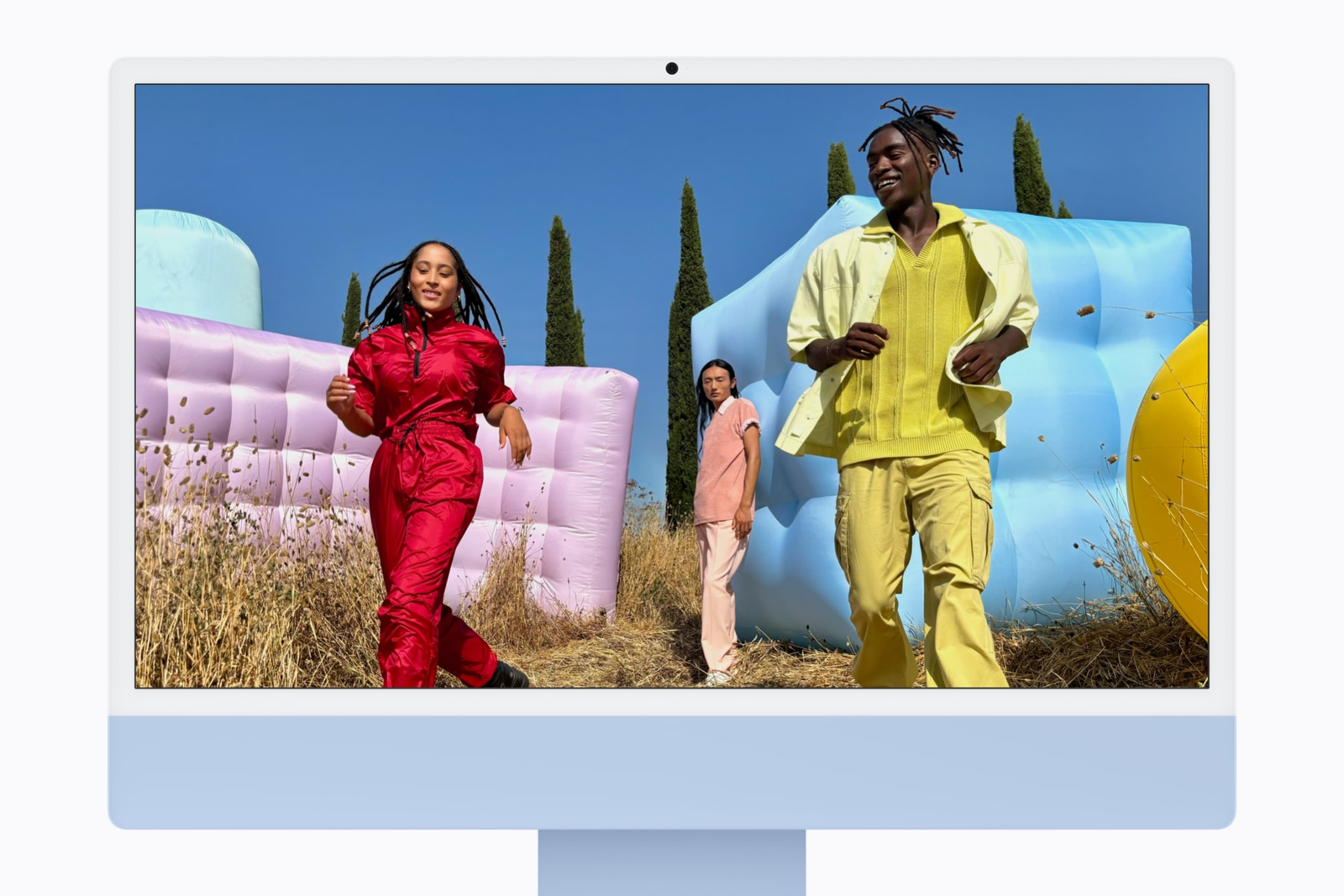 Photo: Apple's new M6 iMac in blue, seen from the front, with three people on its screen.