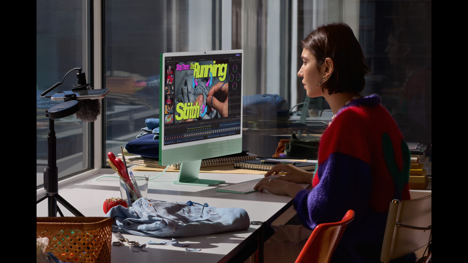 Photo: A woman works on Apple's new green iMac with M6 at a sunny desk.